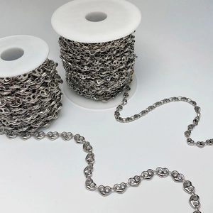 Macro detail of silver heart shaped link chain on reels for DIY jewelry making