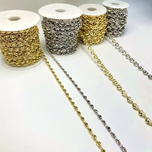 Detailed macro of gold and silver pig nose anchor chains on spools for jewelry making