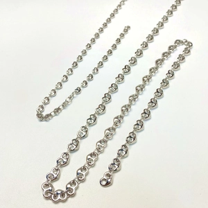 Macro detail of polished silver heart-shaped interlocking chain links for necklaces