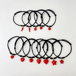 Detailed set of twelve black braided bracelets featuring red heart and chili charms