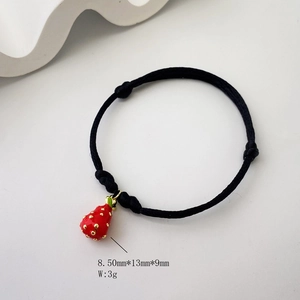 Detail of red strawberry pendant on black braided rope bracelet with dimensions shown