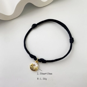 Detail view of black woven rope bracelet with gold Sweet pendant and 1.50g weight spec