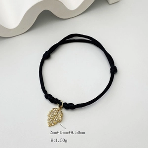 Macro detail of leaf charm with pavé zirconia on black braided bracelet cord