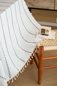 Detailed close-up of blue heart patterns and white tassel edges on Nordic table cloth