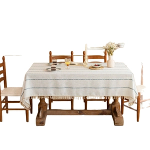 Nordic style rectangular table cloth with blue-green stripes and tassel trim on wooden table