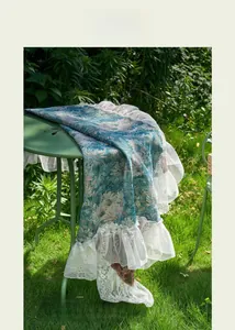 Detail of blue floral jacquard tablecloth with elegant white lace ruffled edges