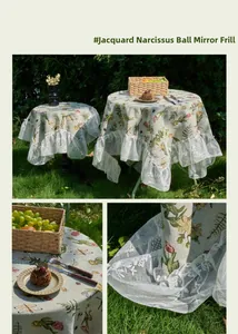 Close-up of jacquard floral fabric with elegant ruffled lace edge on round tablecloth