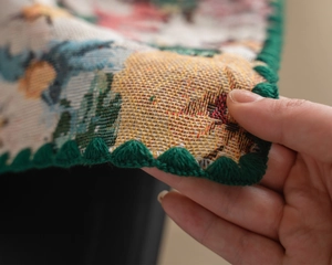 Detailed close-up showing multi-colored jacquard weave texture and dark green scalloped edges