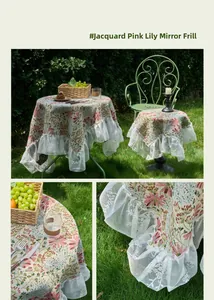 Detailed view of jacquard lily pattern with elegant white lace ruffled edge on pink tablecloth