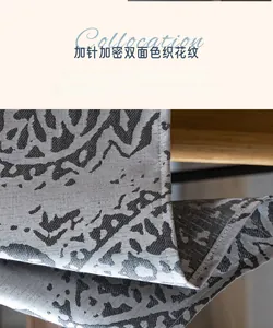 Close-up of thick jacquard tablecloth fabric showing gray teardrop pattern and weaving detail