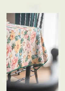 Close-up of vintage floral jacquard tablecloth with intricate green crochet lace edging