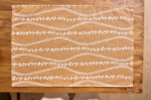 Detail of floral ginger cotton linen napkin with weave texture on dark wood table