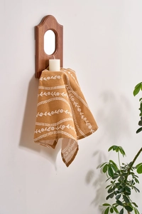 Detail of floral patterns on yellow cotton napkin used as a wall hanging decoration