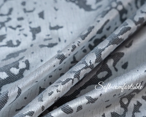 Close-up of silver-gray jacquard fabric with leopard pattern and silky luster texture