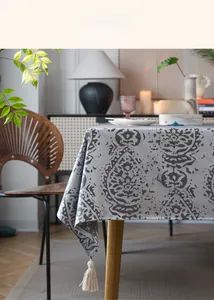 Detail of grey jacquard tablecloth featuring 3D waterdrop texture and beige tassels