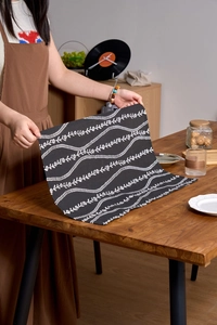 Detail of dark grey floral cotton linen napkin with white flower patterns and neat edges
