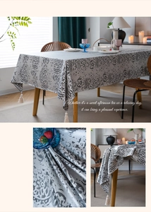 Detailed view of gray jacquard tablecloth fabric texture and decorative corner tassels