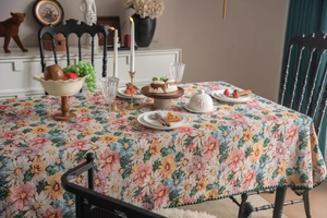 Macro detail of French vintage floral jacquard tablecloth with green scalloped edges