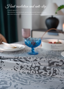 Detail of grey jacquard tablecloth showing embossed floral texture and heat insulation