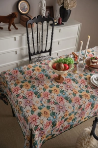 Detail of vintage floral jacquard tablecloth with elegant green pom-pom fringe edges