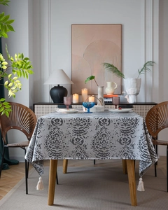 Detail of grey floral tablecloth with elegant white tassels and cotton linen texture