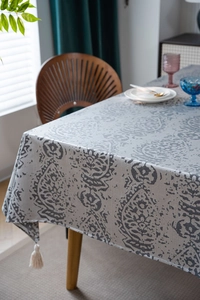 Close-up of gray damascus pattern tablecloth fabric with elegant white corner tassels