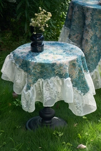 Detailed close-up of blue Monet oil painting style tapestry tablecloth with lace ruffle edge