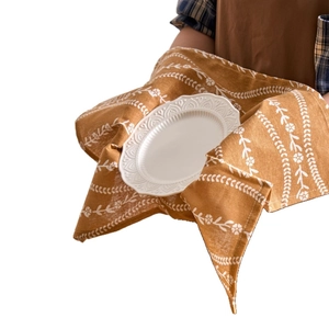 Mustard yellow cotton floral napkin wrapping a white embossed plate for table decor