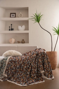 Detail der Vintage-Jacquard-Sofadecke mit dicken Fransen und rotem Blumenmustergewebe