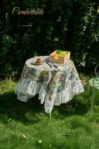 Detailed view of vintage floral jacquard tablecloth with elegant white lace ruffle edges