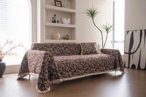 Detail von dickem floralem Jacquard-Stoff mit Quasten und passendem Kissen auf dem Sofa