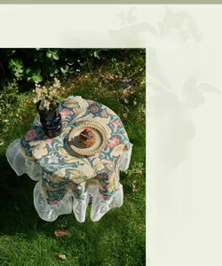 Detail of vintage floral tablecloth with white Victoria lace edge on garden table