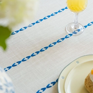 Linen rectangle tablecloth with blue geometric embroidery and fresh table setting