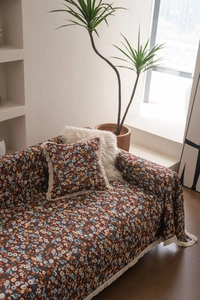 Detailansicht der Jacquard-Sofahusse mit Blumenmuster und passendem Fransenkissen