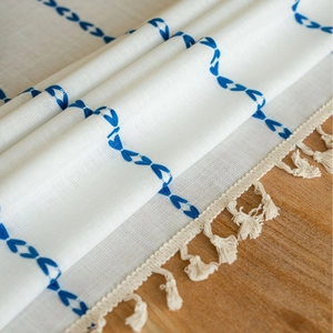 White cotton linen tablecloth with blue floral embroidery and cream tassel fringes