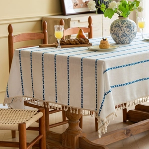 Rectangular cream tablecloth with blue line embroidery and decorative fringe tassels