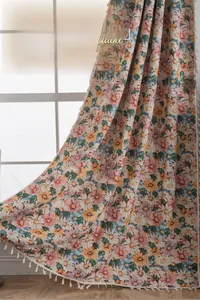 Detailed macro view of French jacquard floral curtains with elegant cream fringe tassels