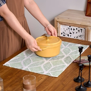 Nordic yellow ceramic dutch oven with metal knob lid on a minimalist dining table