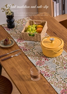 Detail of woven table runner featuring pink floral patterns and insulated non-slip texture