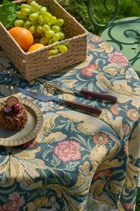 Close-up of vintage green jacquard tablecloth with floral patterns and lace edges