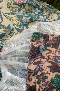 Close-up of vintage floral jacquard fabric with multi-layered white lace edge detailing