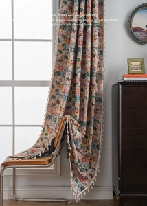 Close-up of floral jacquard curtain fabric with detailed embroidery and fringe edges