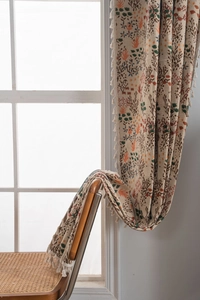 Detail of bohemian floral curtain with fringe trim and premium cotton linen texture