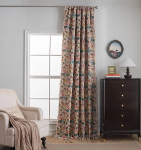 Detailed view of floral curtains with colorful small flowers and white tassel edges