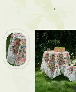Detailed embroidery of pink flowers and white lace trim on an elegant tablecloth