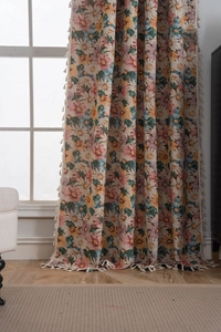 Detailed view of floral curtains with white tassels and colorful daisy embroidery