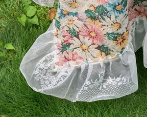 Detail of pink floral jacquard fabric with elegant white lace border on a tablecloth