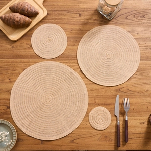 Macro detail of four assorted sizes beige woven cotton round heat resistant table mats