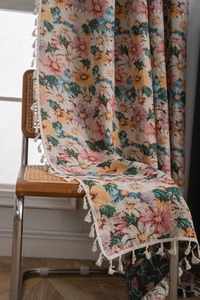 Close-up of floral woven throw with colorful daisy patterns and delicate white fringe