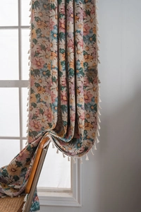 Detail of floral jacquard curtain with elegant cream tassels and colorful flower pattern